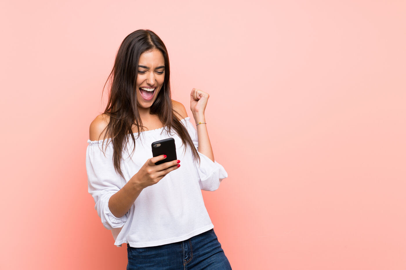 Excited woman celebrating good news on her phone