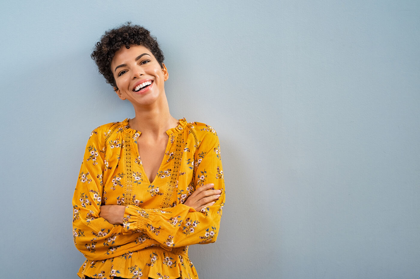 Smiling woman in a yellow floral blouse